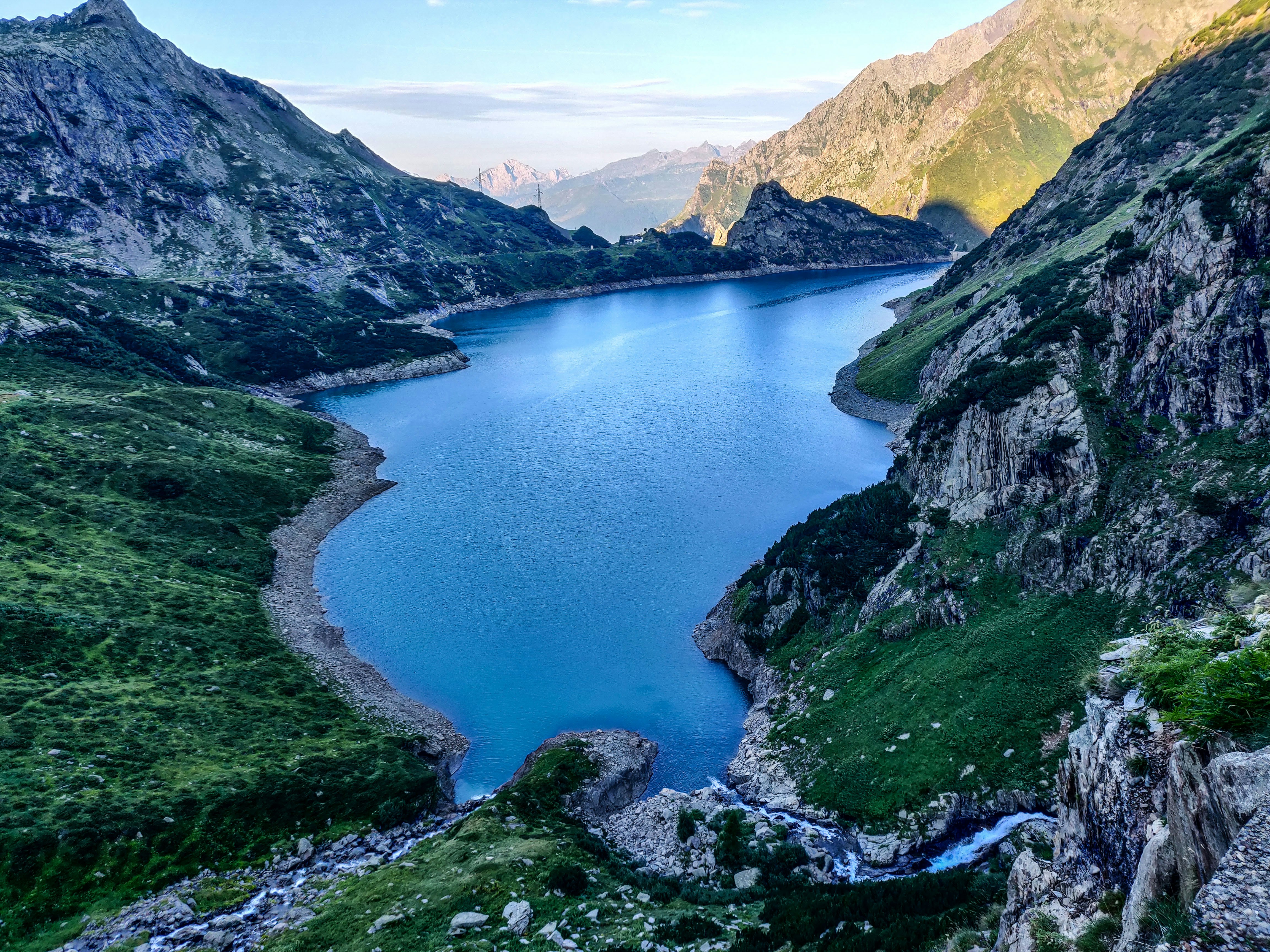 lake in the middle of mountains during daytime