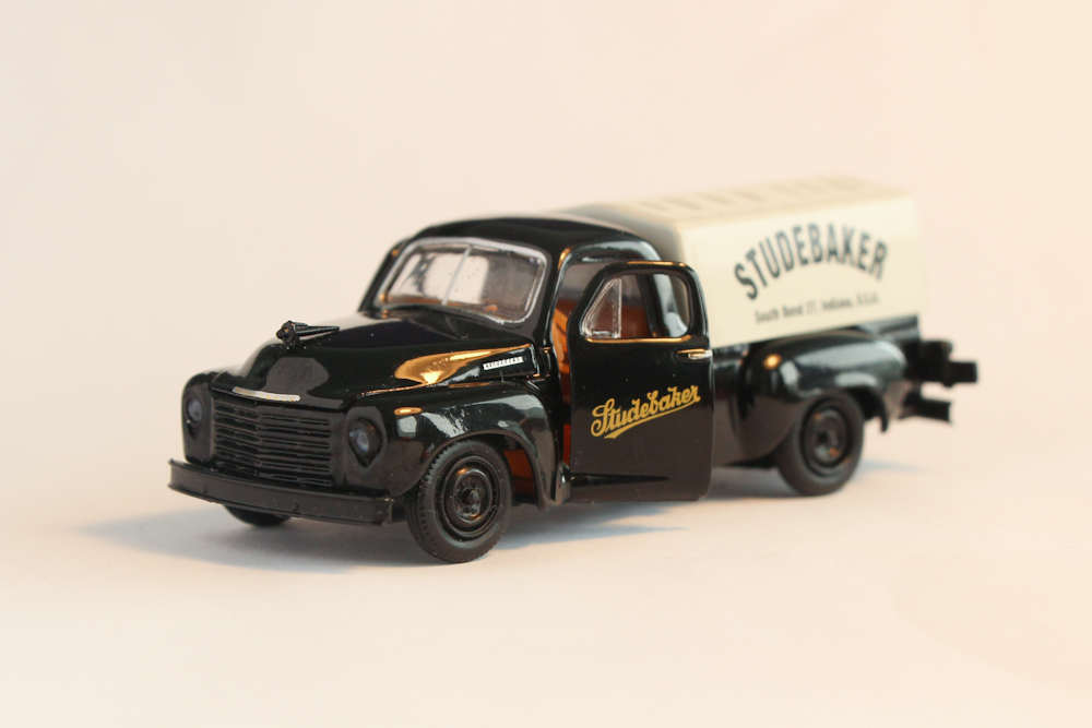 a black toy truck with a white trailer