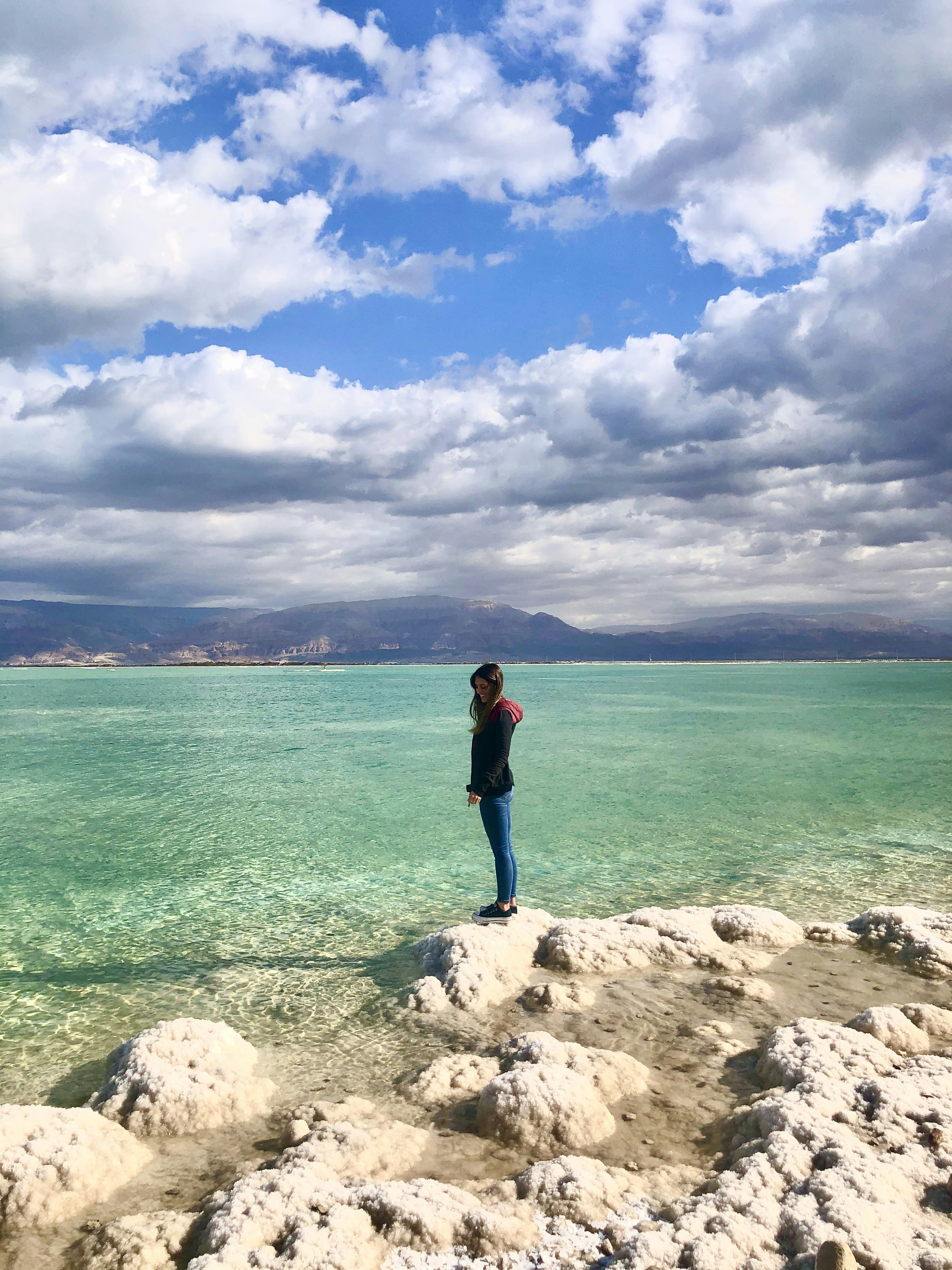 Tourists floating in the Dead Sea with salt formations Israel