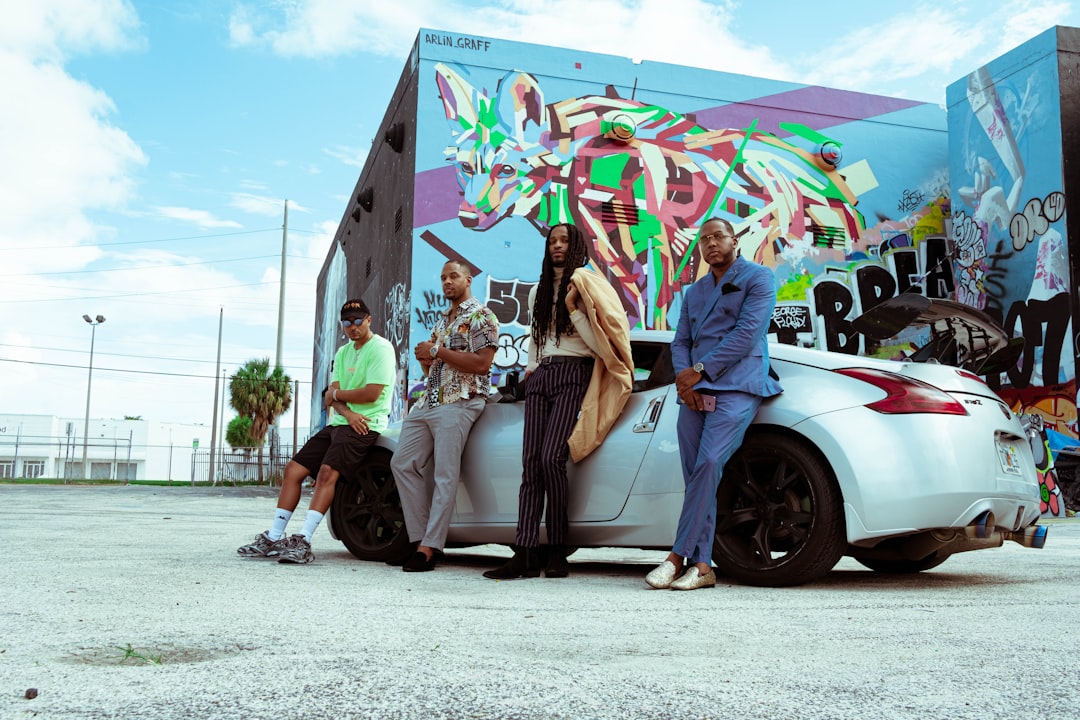 woman in purple long sleeve shirt sitting on white car during daytime