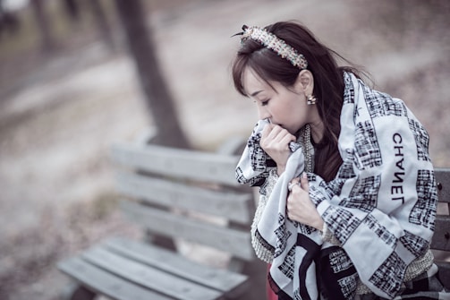 Close-up of cozy scarves and gloves on a bench.