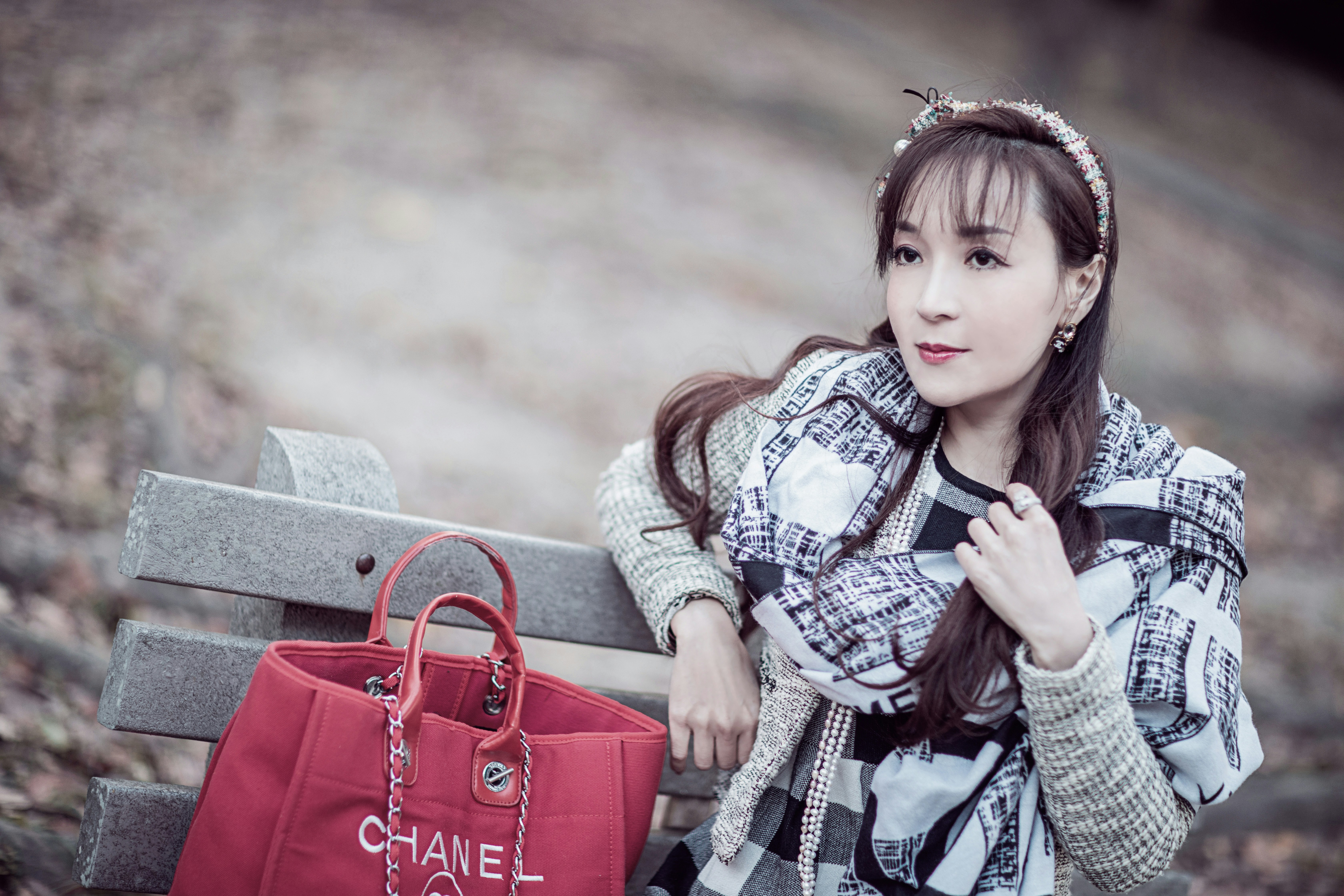 woman in black and white long sleeve shirt sitting on gray concrete bench during daytime