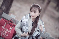 A vibrant scarf draped over a classic leather jacket on a rustic bench.