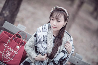 A vibrant scarf draped over a classic leather jacket on a rustic bench.
