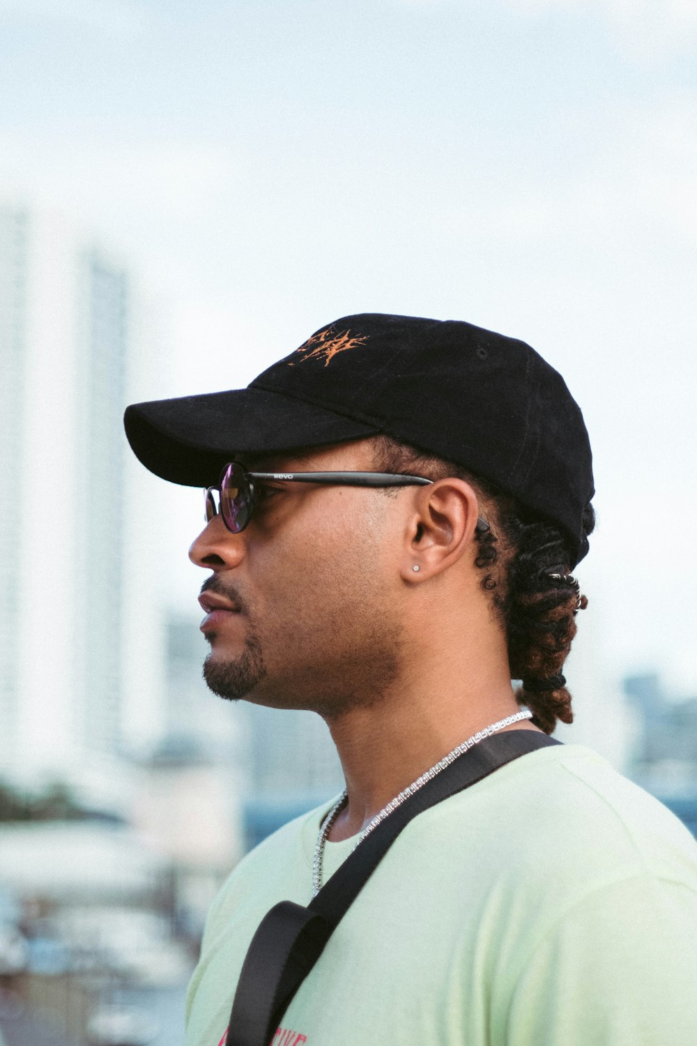 man in white collared shirt wearing black cap