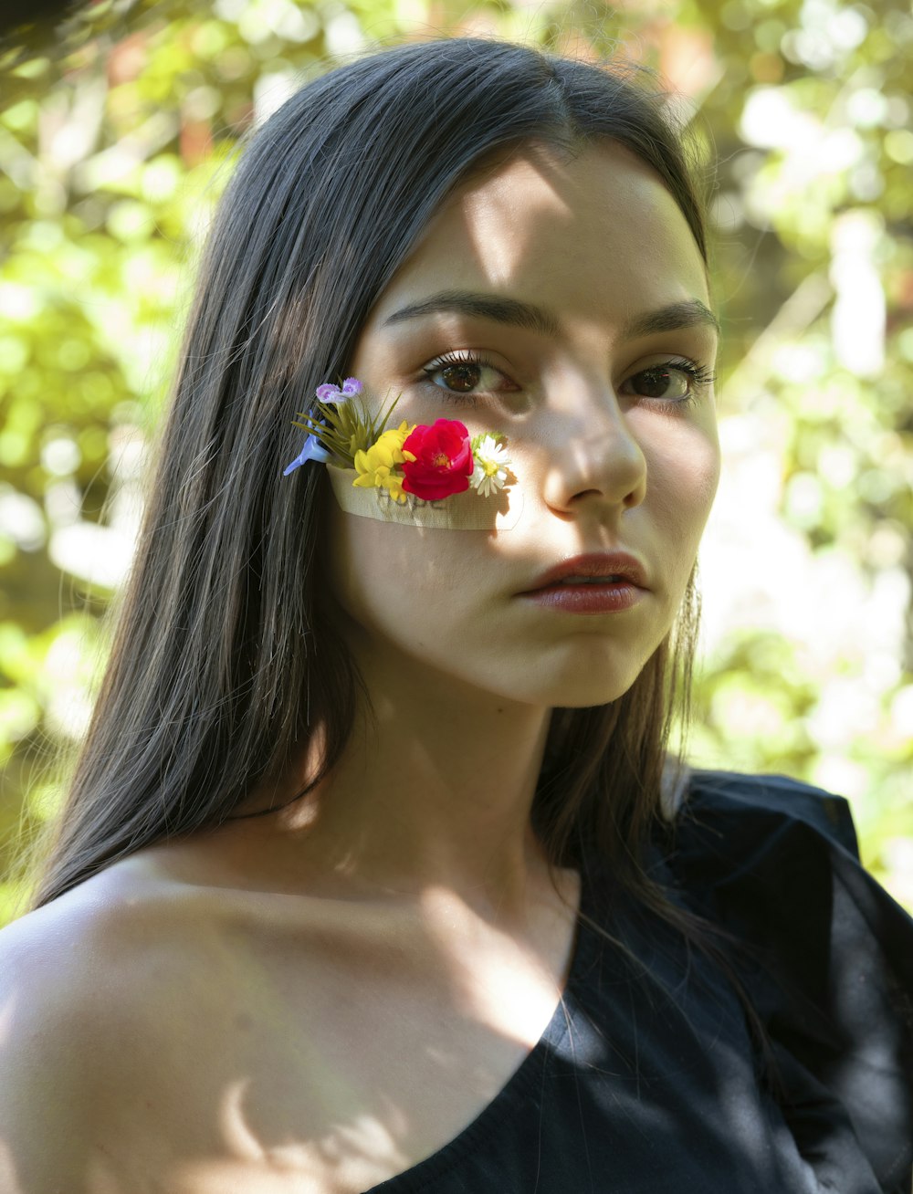 woman in black shirt with red and white flower on her ear