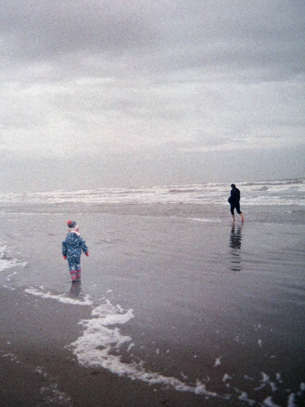 2 pessoas caminhando na praia durante o dia