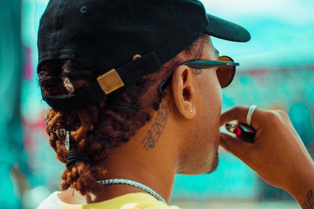 man in black sunglasses and black cap