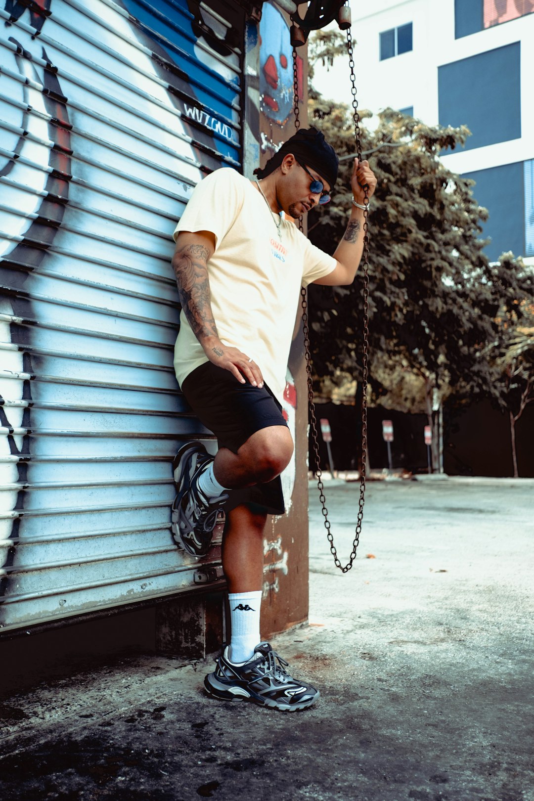 man in white crew neck t-shirt and black shorts sitting on gray wooden bench during