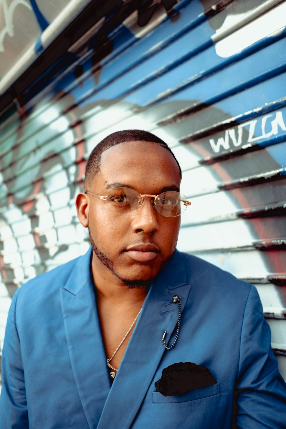 Hombre con camisa azul abotonada con gafas de montura negra