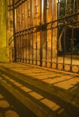 black metal gate on brown concrete wall