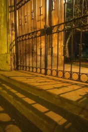 black metal gate on brown concrete wall