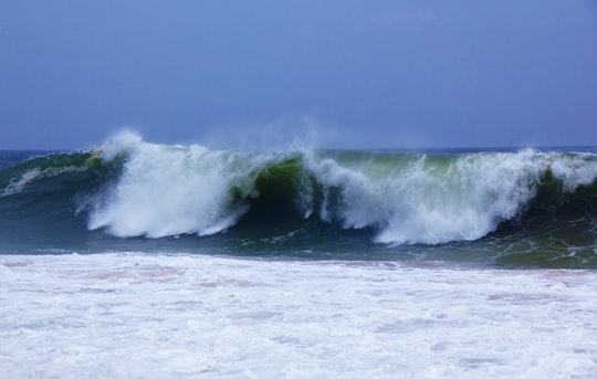 ocean waves crashing on shore during daytime in Kovalam India