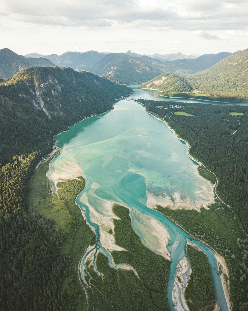 aerial view of green mountains and lake during daytime