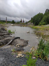 An industrial limestone quarry with heavy machinery and workers operating under a clear sky.