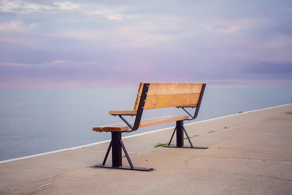 brown wooden bench on beach during daytime