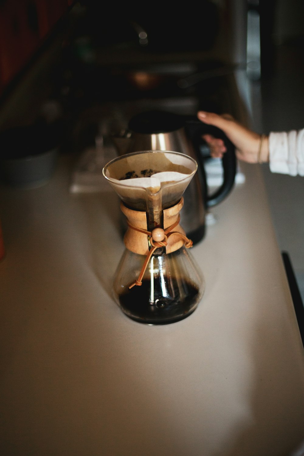 person pouring coffee on silver cup