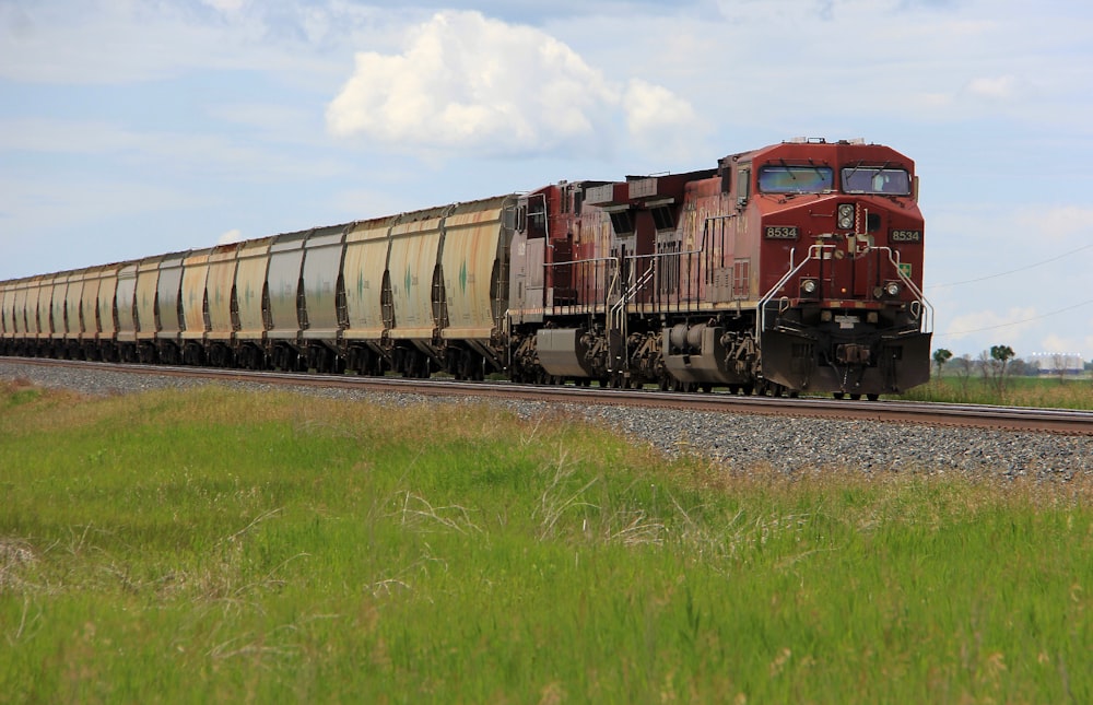 red train on rail tracks during daytime