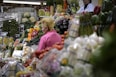 a woman standing in front of a display of fruits and vegetables