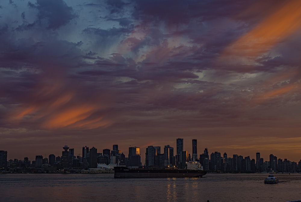 city skyline under orange and blue cloudy sky during sunset