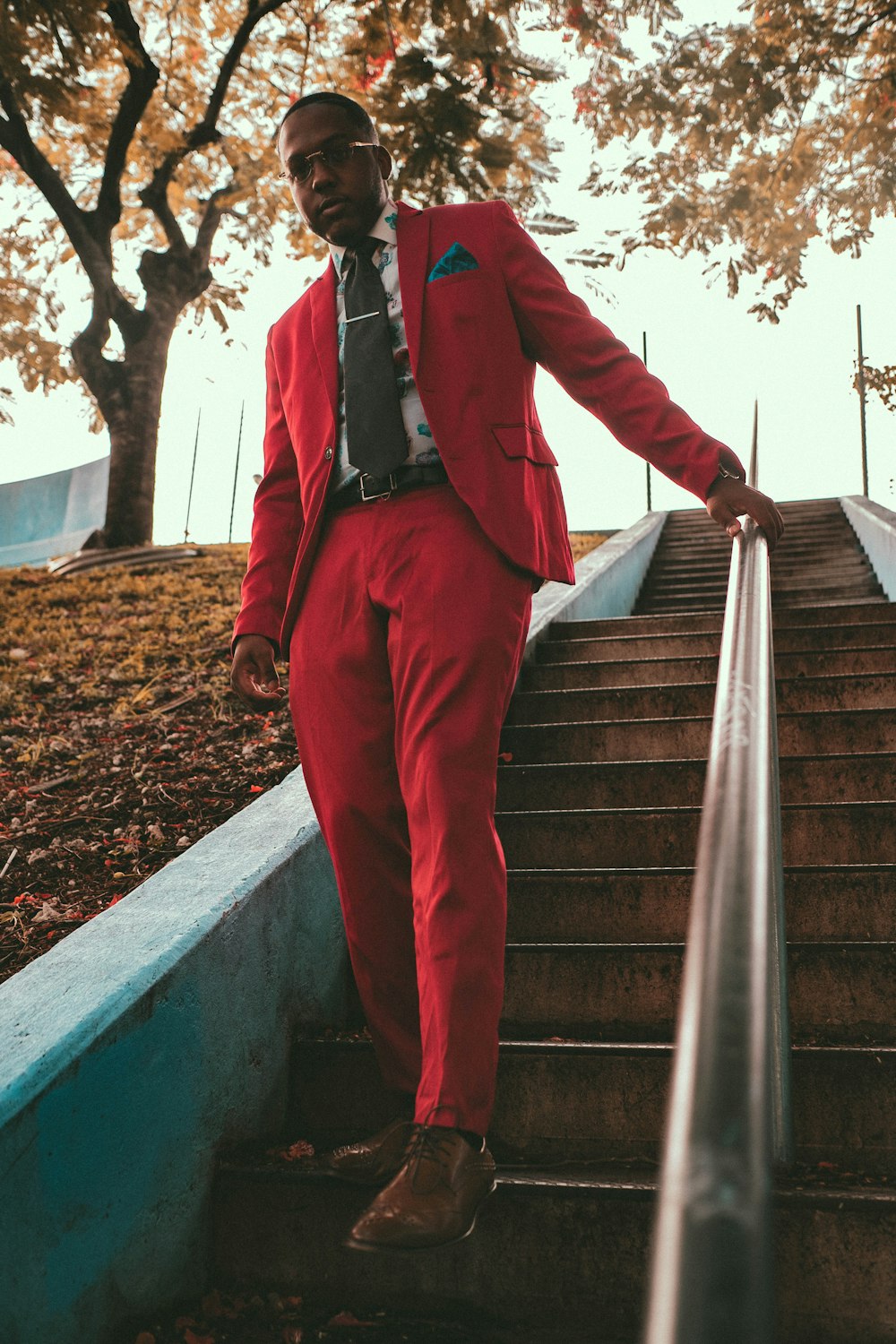 階段の上に立っている赤いスーツを着た男