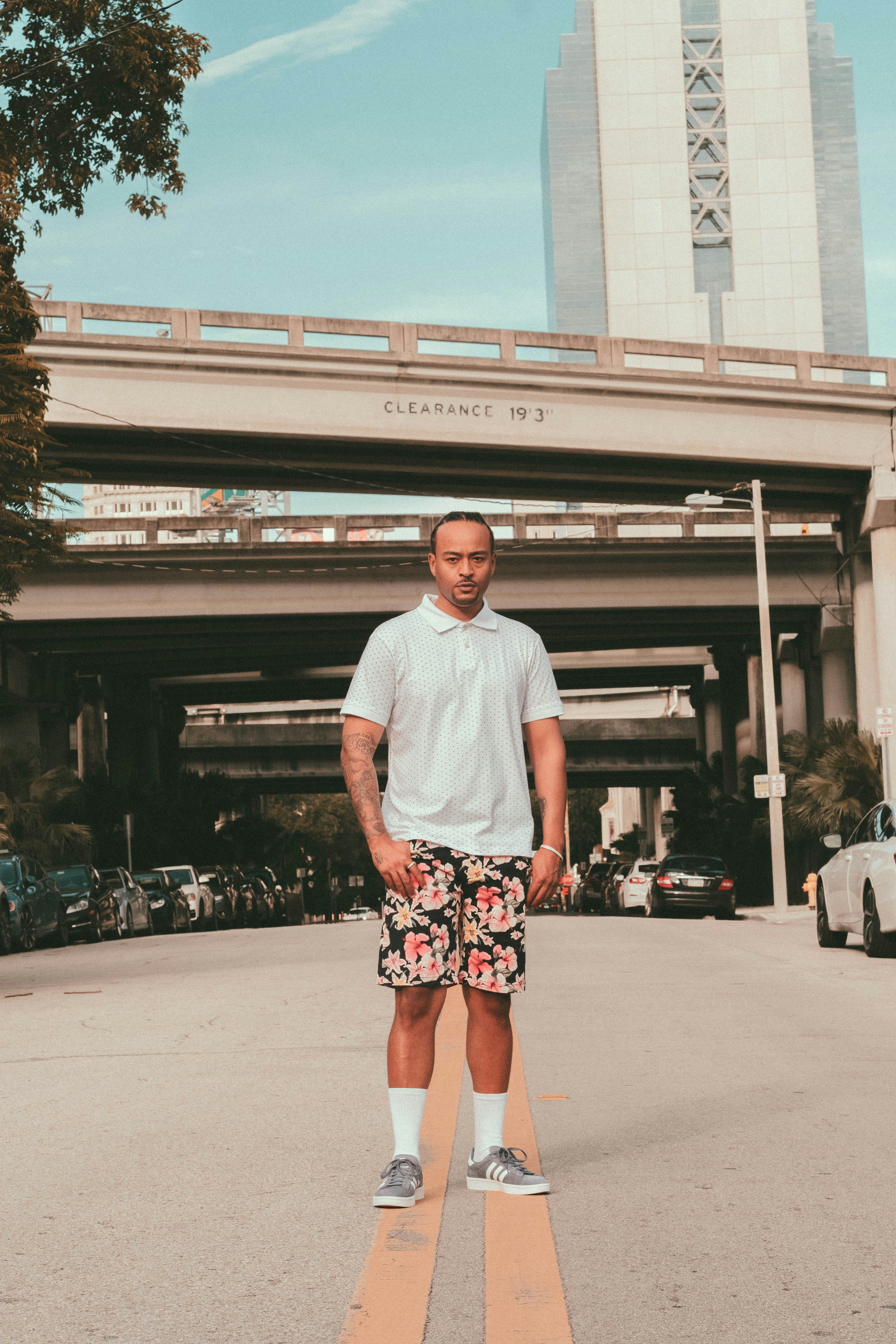 man in white crew neck t-shirt standing on gray concrete floor during daytime