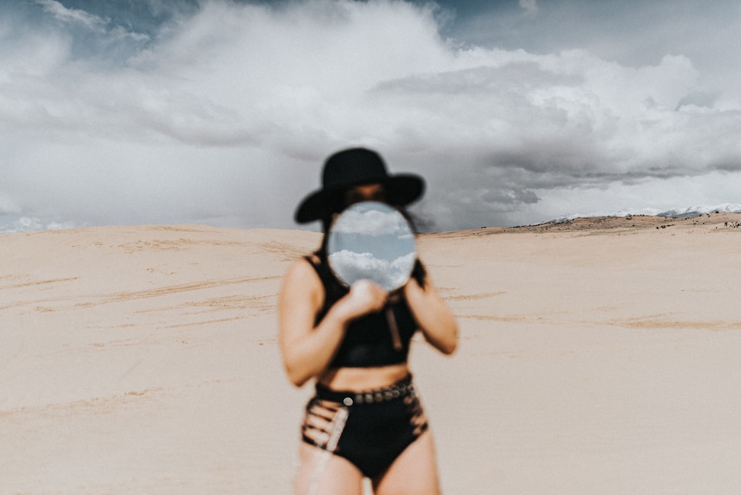 woman in black bikini holding clear plastic bottle