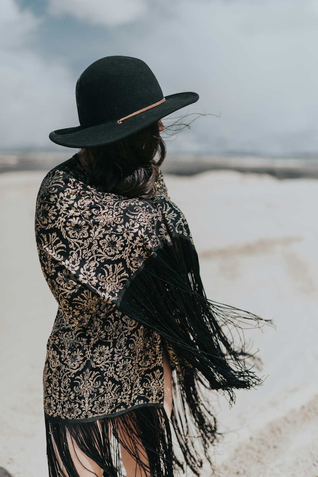 woman in black hat standing on snow covered ground during daytime