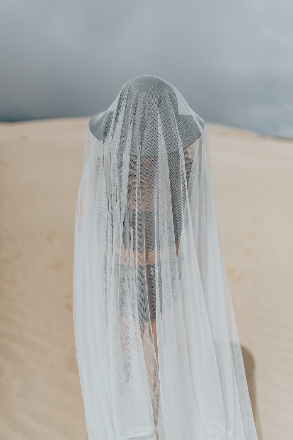 textile transparent blanc sur sable brun