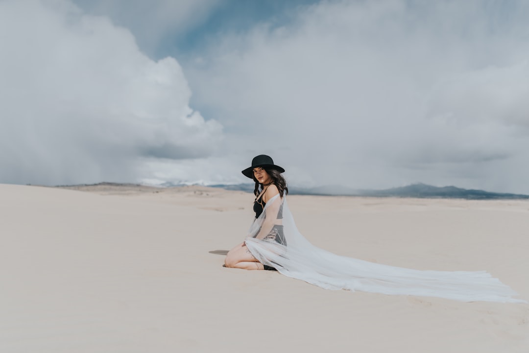 woman in white dress walking on sand during daytime