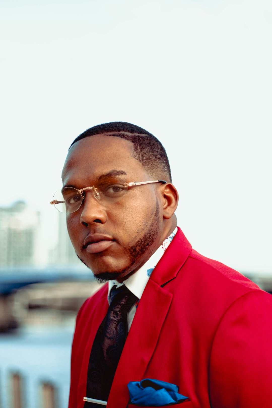 man in red suit wearing black framed eyeglasses