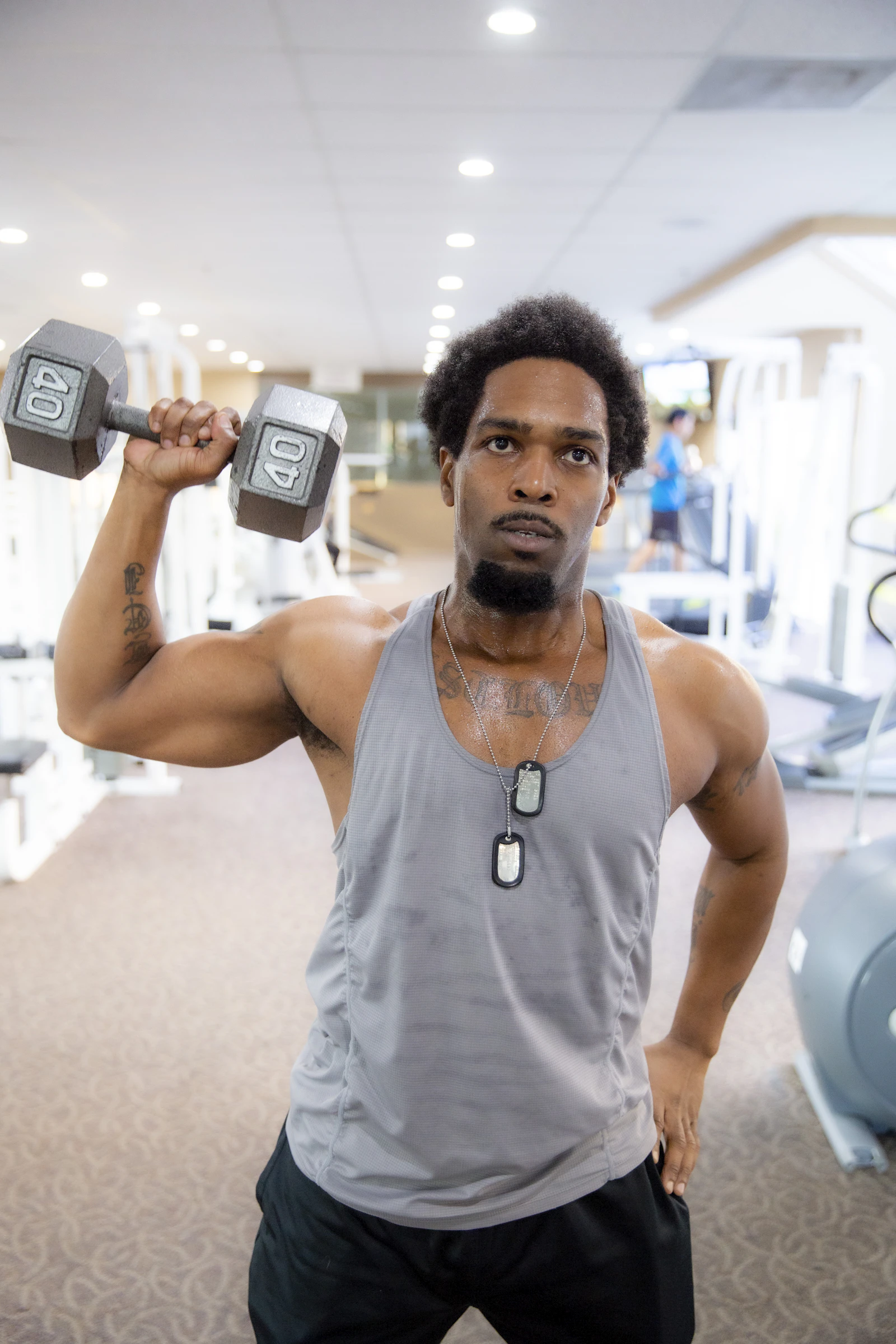 Sample coach portrait: a man holding a dumbbell in a gym (stock photo)