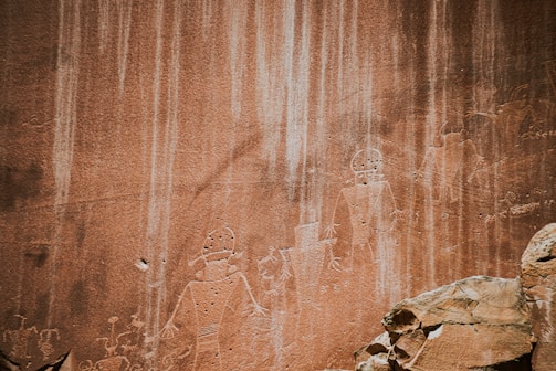 A detailed photograph of prehistoric rock art on a rugged stone surface.