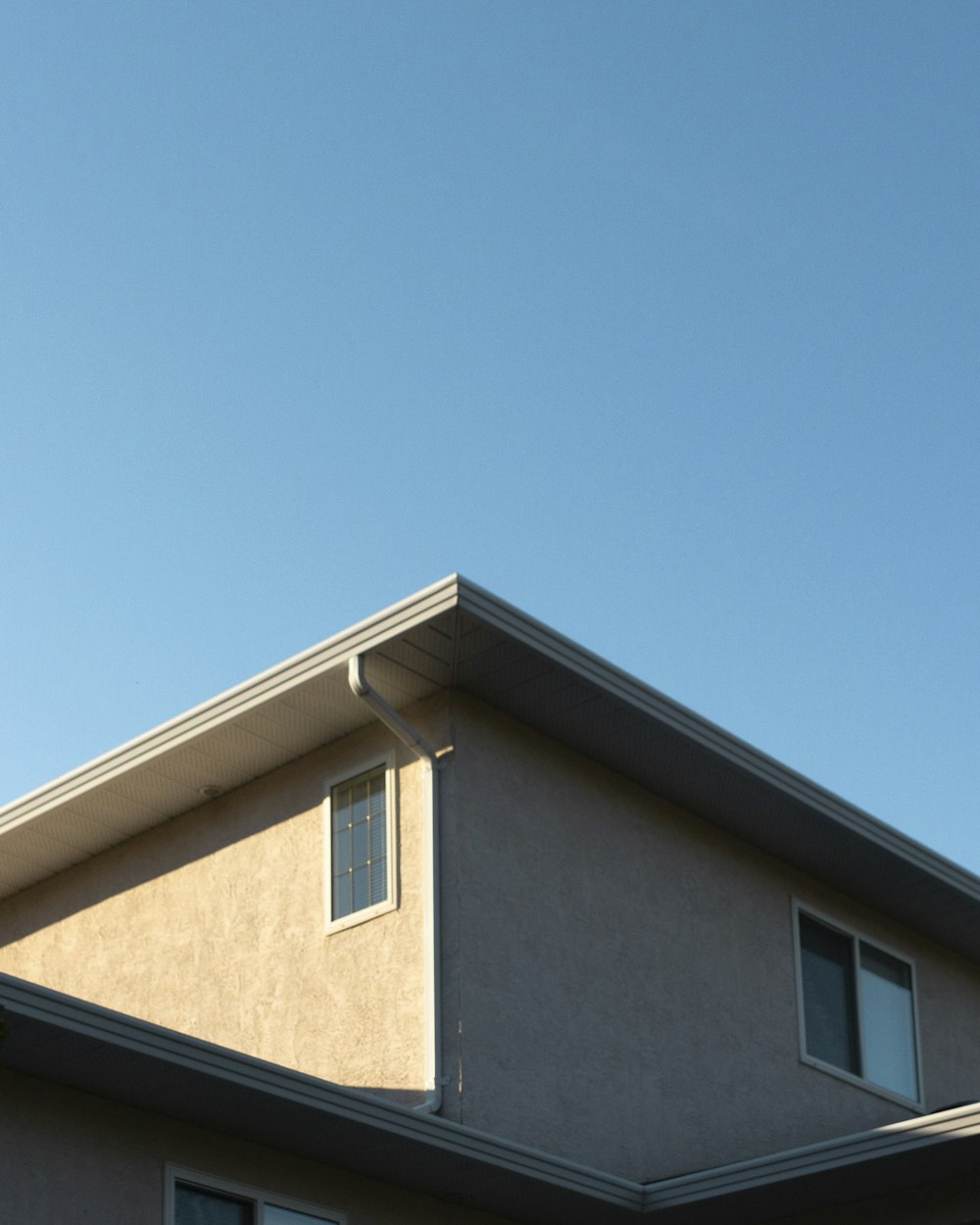 낮 동안 푸른 하늘 아래 갈색 콘크리트 집