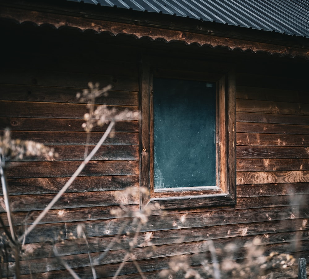 Casa de ladrillo marrón con ventana de madera azul