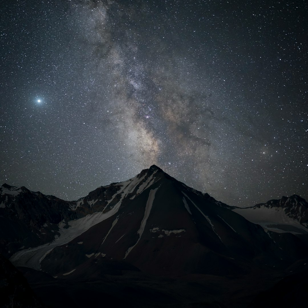 snow covered mountain under starry night