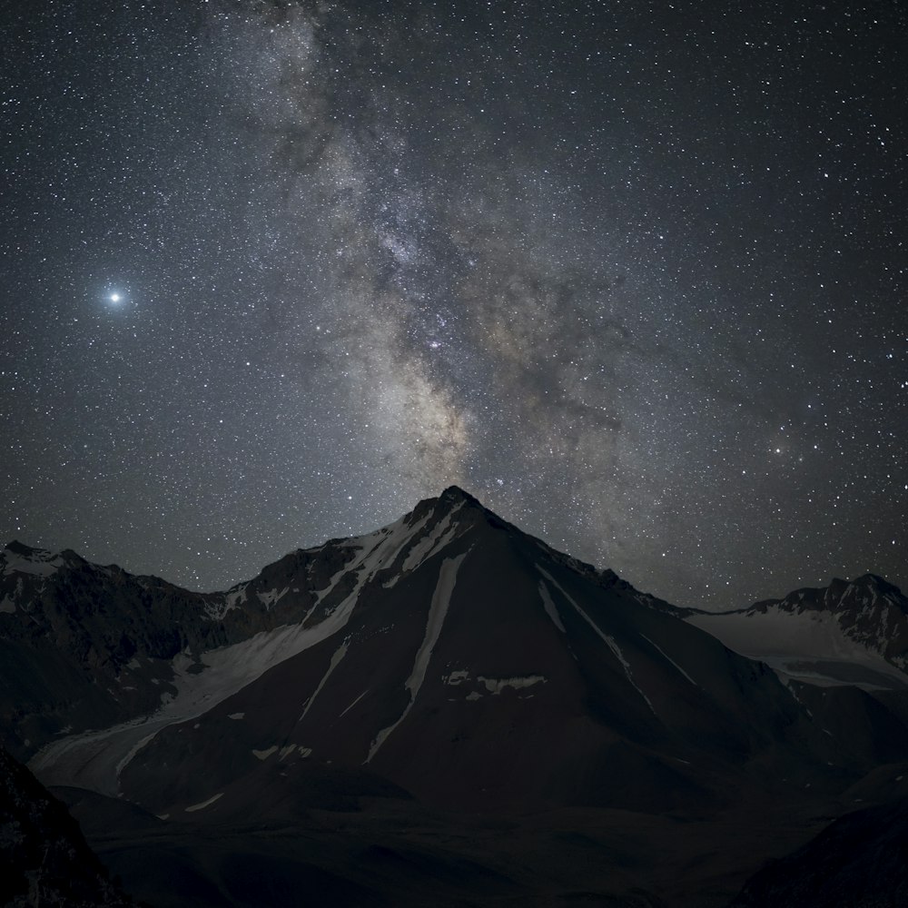 snow covered mountain under starry night