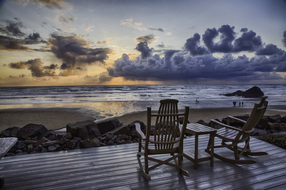 sedia a dondolo in legno marrone sulla spiaggia durante il tramonto