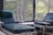 A serene living room with a massage chair positioned near a window, inviting relaxation.