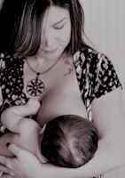 A warm, softly lit scene of a mother breastfeeding her baby in a cozy, minimalist room.