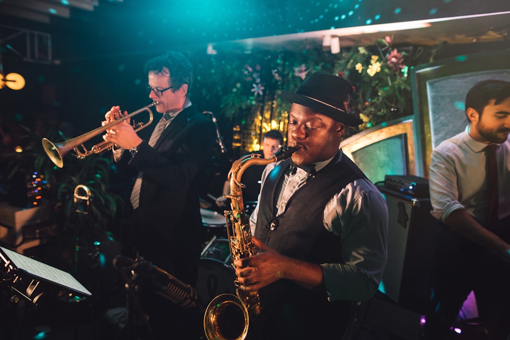 2 men playing trumpet during nighttime