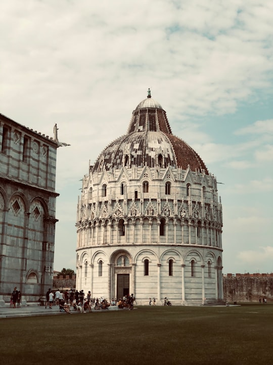 people walking near white concrete building during daytime in Piazza dei Miracoli Italy