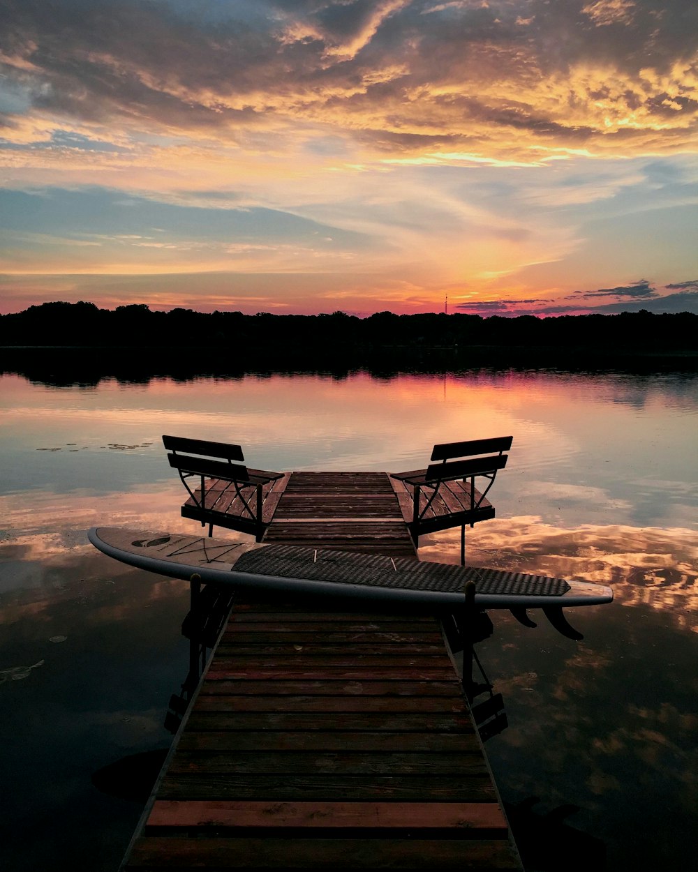 Braune Holzbank am Dock bei Sonnenuntergang