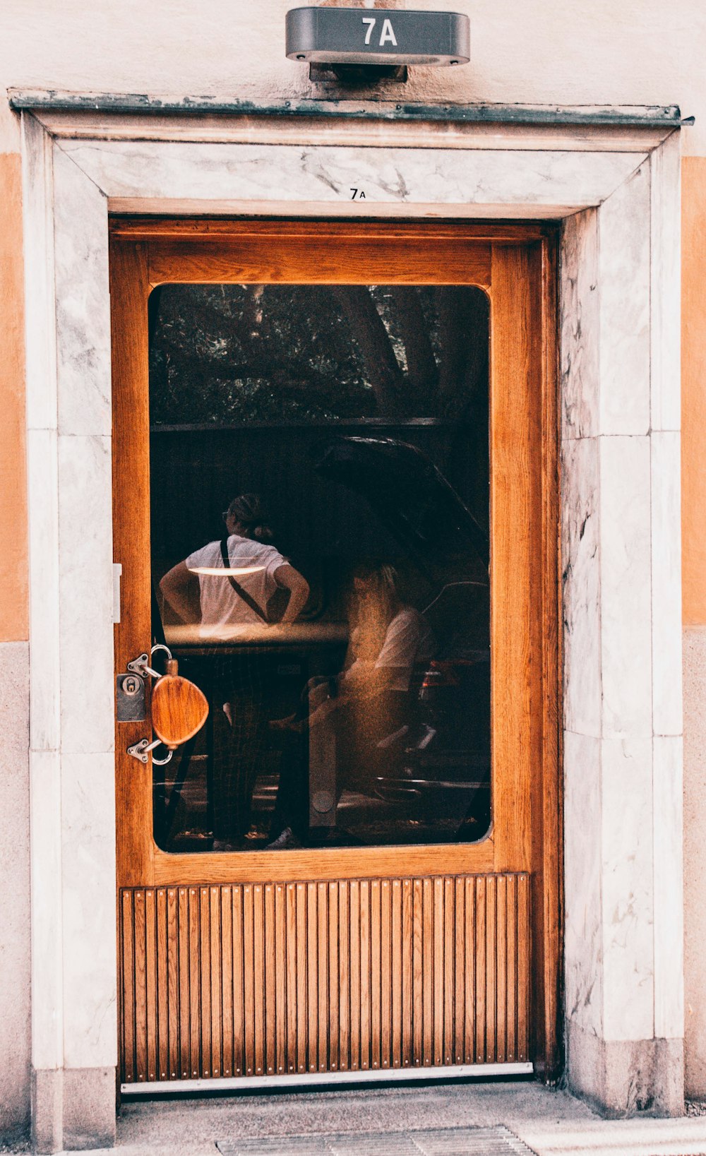 man in white dress shirt and black sunglasses in front of brown wooden framed mirror