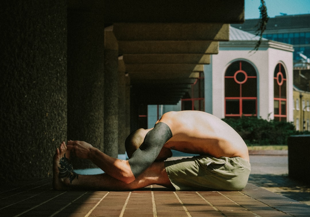 man in white shorts sitting on brown wooden floor