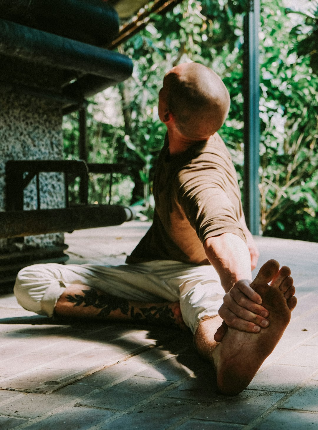 man in black t-shirt and brown pants sitting on floor