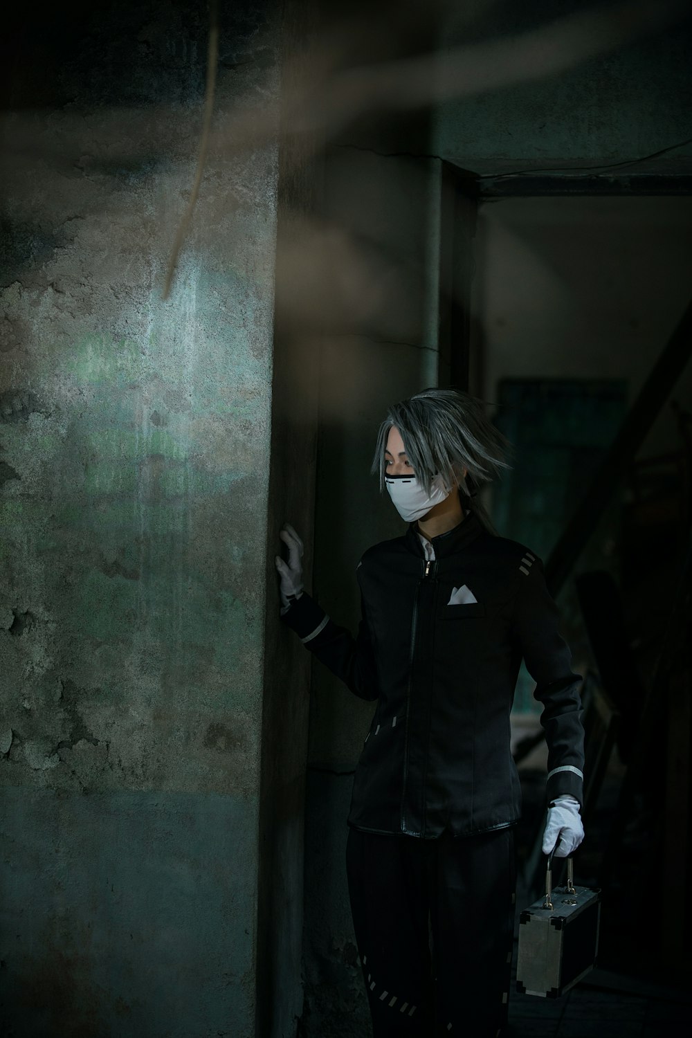woman in black jacket standing beside gray concrete wall