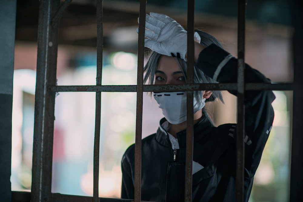 person in black jacket covering face with white textile