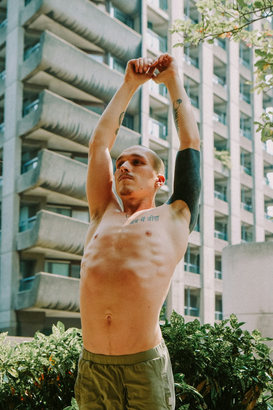 topless man in black shorts raising his right hand