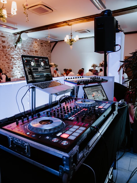 A laptop, mixer, and DJ controller prepared for a private event booking.